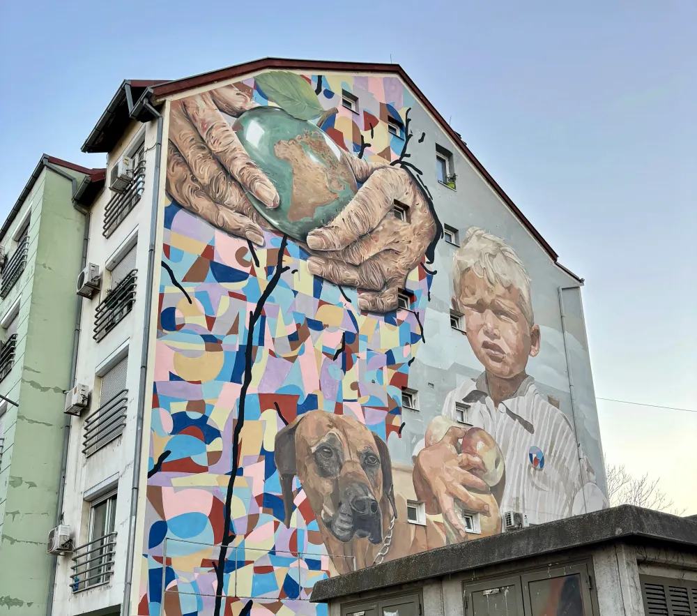 Amazing painting of a boy and a dog next to the earth on a building