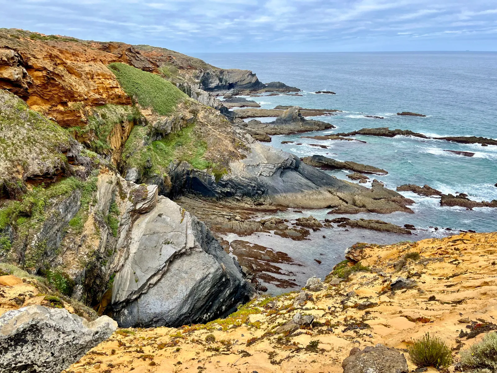 An impressive colourfull cliff, a great contrast with the ocean blue